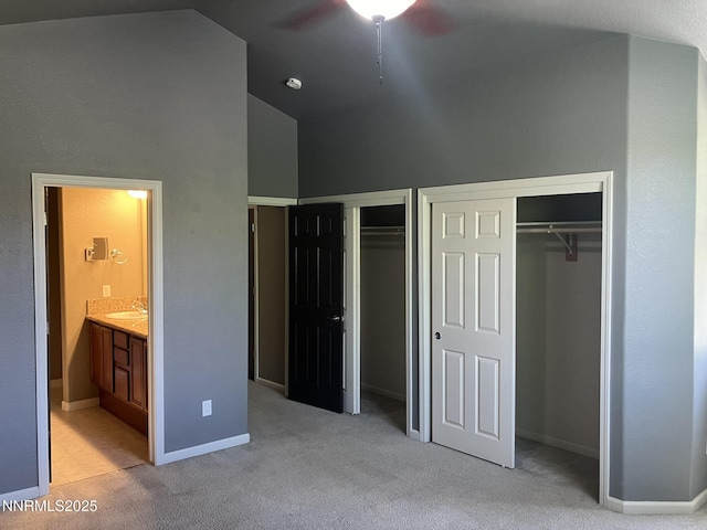 5619 Crescent Hill Way, Sparks, NV 89436 - unfurnished bedroom featuring two closets, light colored carpet, a sink, high vaulted ceiling, and ensuite bathroom