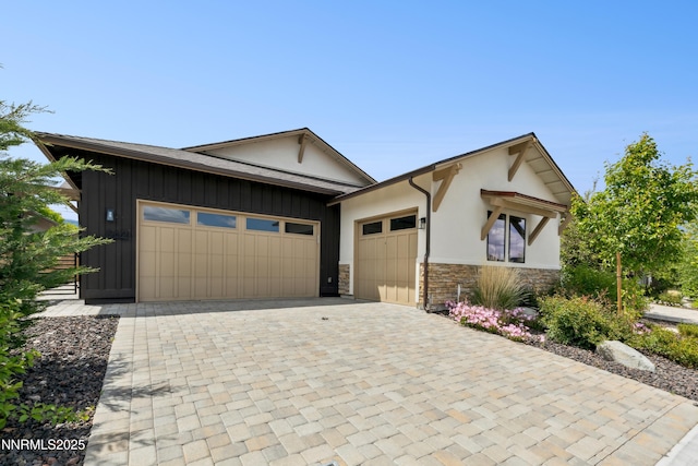 9621 Lane Garrett Dr, Reno, NV 89511 - view of front facade featuring stone siding, a garage, decorative driveway, and stucco siding