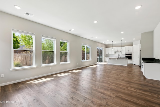 9621 Lane Garrett Dr, Reno, NV 89511 - unfurnished living room featuring recessed lighting, a sink, dark wood-type flooring, and baseboards