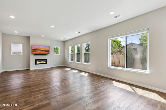 9621 Lane Garrett Dr, Reno, NV 89511 - unfurnished living room with dark wood-style floors, baseboards, a glass covered fireplace, and recessed lighting
