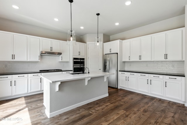 9621 Lane Garrett Dr, Reno, NV 89511 - kitchen featuring stainless steel appliances, under cabinet range hood, decorative backsplash, white cabinetry, and recessed lighting