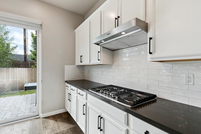 9621 Lane Garrett Dr, Reno, NV 89511 - kitchen featuring range hood, stainless steel gas stovetop, dark countertops, white cabinets, and dark wood-style flooring