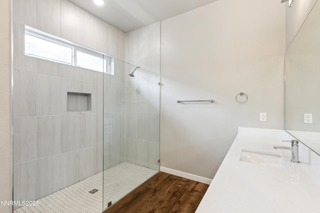 9621 Lane Garrett Dr, Reno, NV 89511 - bathroom featuring tiled shower, vanity, wood finished floors, and baseboards
