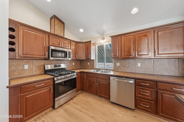1260 Badger St, Silver Springs, NV 89429 - kitchen with stainless steel appliances, a sink, lofted ceiling, light wood-style flooring, and tasteful backsplash