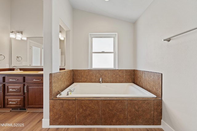1260 Badger St, Silver Springs, NV 89429 - bathroom with vanity, a garden tub, lofted ceiling, and wood finished floors