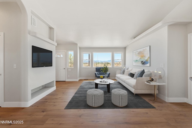 1260 Badger St, Silver Springs, NV 89429 - living room featuring baseboards, light wood-style flooring, and arched walkways