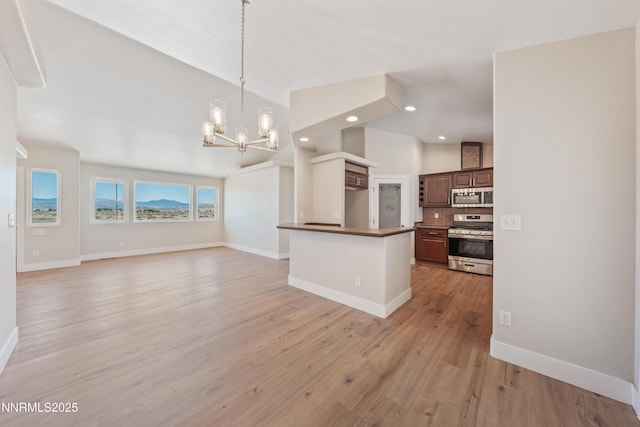 1260 Badger St, Silver Springs, NV 89429 - kitchen with appliances with stainless steel finishes, a chandelier, open floor plan, light wood-style flooring, and dark countertops