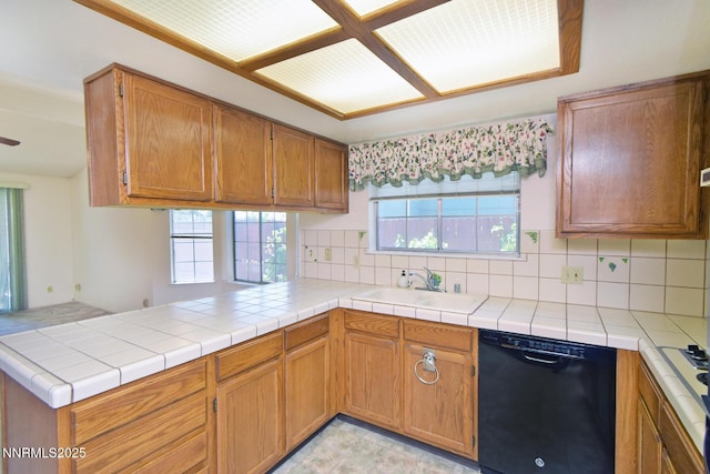 1664 Shadow Wood Rd, Reno, NV 89523 - kitchen with black dishwasher, tasteful backsplash, a peninsula, brown cabinetry, and light countertops