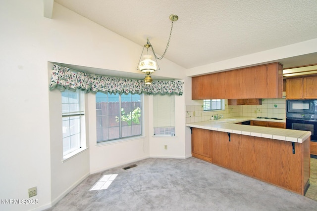 1664 Shadow Wood Rd, Reno, NV 89523 - kitchen featuring brown cabinets, black appliances, tile countertops, tasteful backsplash, and lofted ceiling