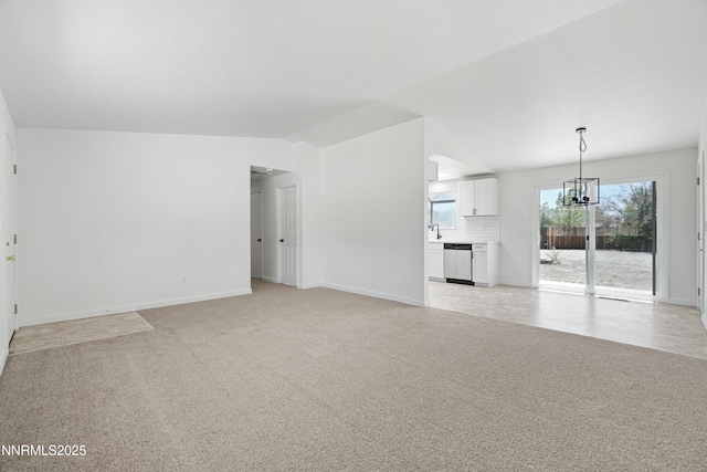 266 River Boat Rd, Dayton, NV 89403 - unfurnished living room with light colored carpet, a chandelier, vaulted ceiling, baseboards, and a sink