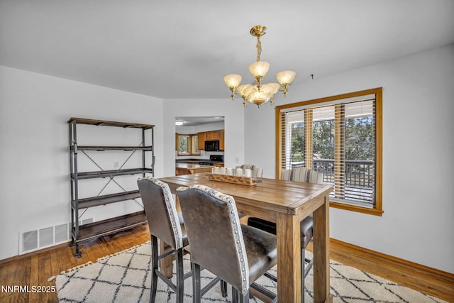 670 Valle Verde Dr, Sparks, NV 89441 - dining area with a chandelier, wood finished floors, and baseboards