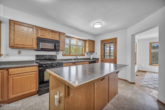 670 Valle Verde Dr, Sparks, NV 89441 - kitchen with black appliances, a kitchen breakfast bar, dark countertops, a sink, and a kitchen island