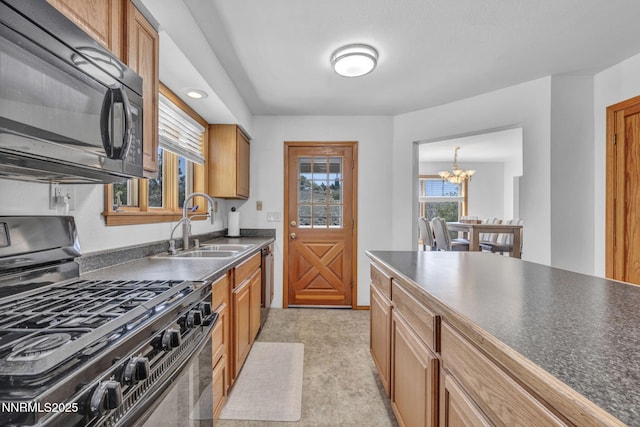 670 Valle Verde Dr, Sparks, NV 89441 - kitchen with black appliances, dark countertops, a chandelier, a sink, and brown cabinetry