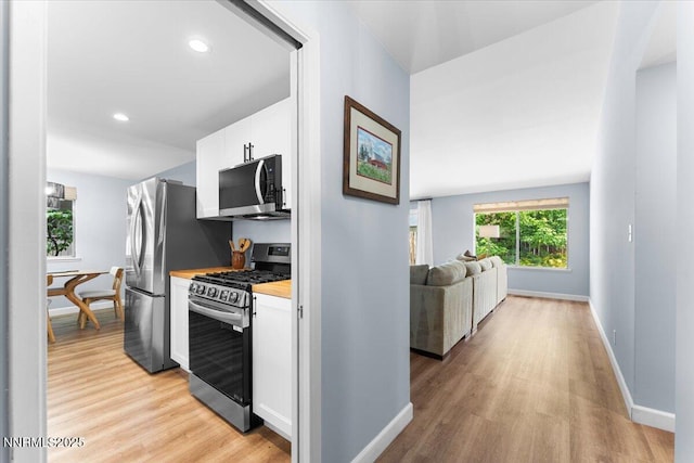 1832 Espee Ct, Sparks, NV 89434 - kitchen with stainless steel appliances, light wood finished floors, white cabinetry, baseboards, and recessed lighting
