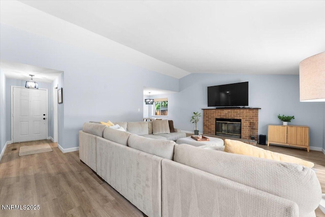 1832 Espee Ct, Sparks, NV 89434 - living room with baseboards, light wood finished floors, lofted ceiling, and a brick fireplace