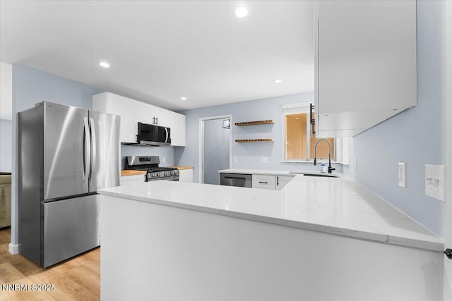 1832 Espee Ct, Sparks, NV 89434 - kitchen featuring stainless steel appliances, a sink, light wood-type flooring, light stone countertops, and white cabinets