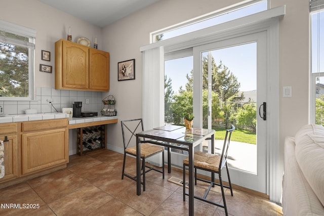 7100 Heatherwood Dr, Reno, NV 89523 - kitchen featuring tile counters, plenty of natural light, decorative backsplash, and light brown cabinetry