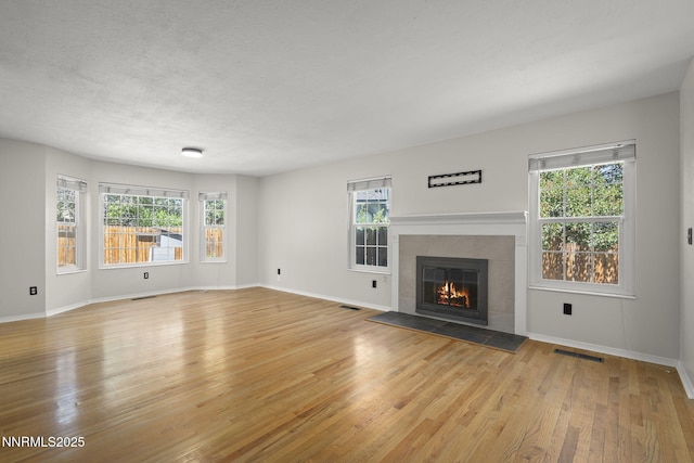 2125 Woodhaven Ln, Sparks, NV 89434 - unfurnished living room featuring light wood-type flooring, a tile fireplace, and baseboards