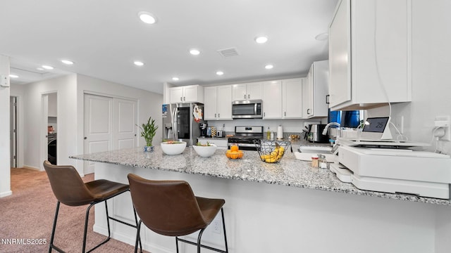 640 Mcgill Dr, Reno, NV 89506 - kitchen with stainless steel appliances, a sink, a peninsula, light stone counters, and recessed lighting