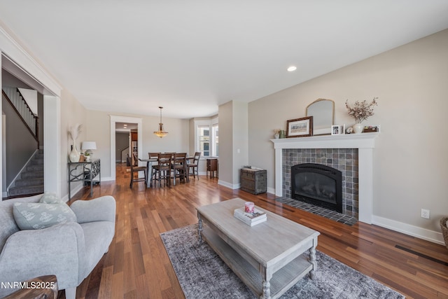 1011 Keystone Ct, Gardnerville, NV 89460 - living area with a tiled fireplace, stairs, wood finished floors, baseboards, and recessed lighting
