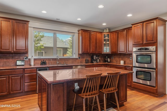 1011 Keystone Ct, Gardnerville, NV 89460 - kitchen with appliances with stainless steel finishes, a sink, light wood finished floors, dark stone counters, and recessed lighting