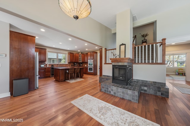 1011 Keystone Ct, Gardnerville, NV 89460 - living room with beverage cooler, light wood-style floors, recessed lighting, a multi sided fireplace, and a high ceiling