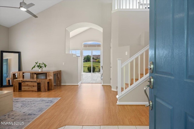 6740 Cinnamon Dr, Sparks, NV 89436 - entrance foyer featuring wood finished floors, high vaulted ceiling, ceiling fan, stairway, and arched walkways