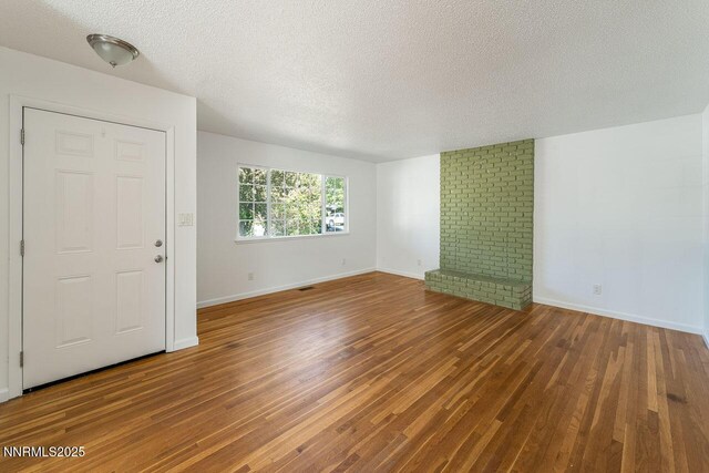 201 N Carson Meadow Dr, Carson City, NV 89701 - unfurnished living room with a textured ceiling, wood finished floors, and baseboards