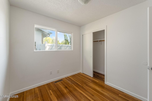 201 N Carson Meadow Dr, Carson City, NV 89701 - unfurnished bedroom featuring wood finished floors, a closet, baseboards, and a textured ceiling