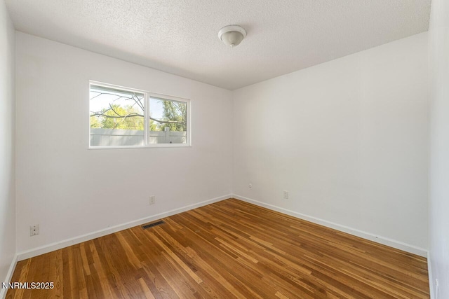 201 N Carson Meadow Dr, Carson City, NV 89701 - unfurnished room with wood finished floors, baseboards, and a textured ceiling