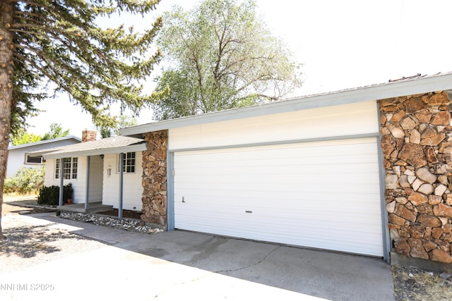 201 N Carson Meadow Dr, Carson City, NV 89701 - ranch-style house featuring stone siding, a chimney, a porch, a garage, and concrete driveway