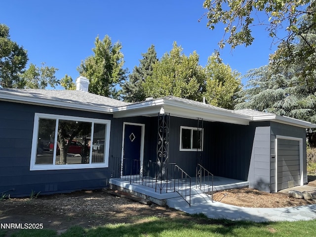 2485 Riviera St, Reno, NV 89509 - ranch-style house featuring a garage, a chimney, and covered porch