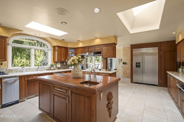 5101 Eldorado Dr, Reno, NV 89519 - kitchen featuring appliances with stainless steel finishes, a skylight, a sink, an island with sink, and healthy amount of natural light
