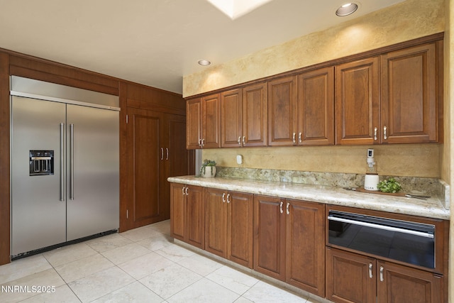 5101 Eldorado Dr, Reno, NV 89519 - kitchen featuring stainless steel built in refrigerator, brown cabinets, light tile patterned flooring, recessed lighting, and oven