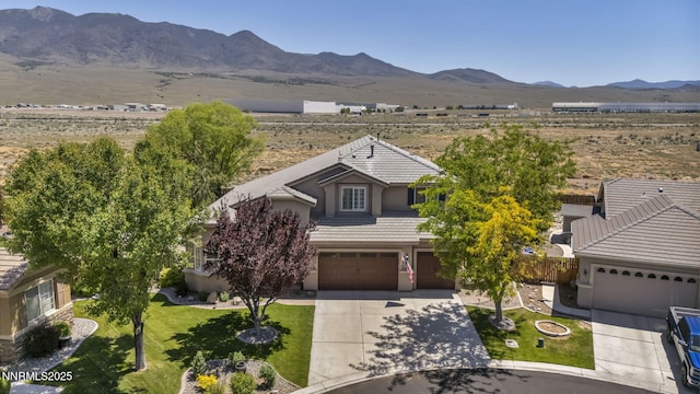 212 Portrush Ct, Dayton, NV 89403 - view of front of house featuring a tile roof, a garage, concrete driveway, a mountain view, and stucco siding