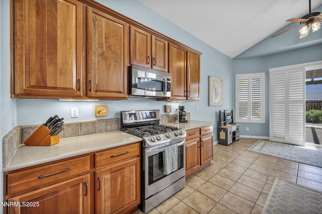 212 Portrush Ct, Dayton, NV 89403 - kitchen featuring appliances with stainless steel finishes, lofted ceiling, ceiling fan, brown cabinets, and light tile patterned floors