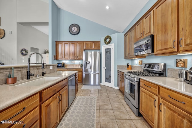 212 Portrush Ct, Dayton, NV 89403 - kitchen with stainless steel appliances, a sink, high vaulted ceiling, brown cabinets, and light countertops