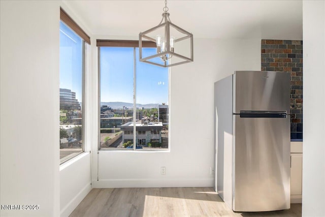 280 Island Ave Apt 906, Reno, NV 89501 - unfurnished dining area with a chandelier and light wood-type flooring