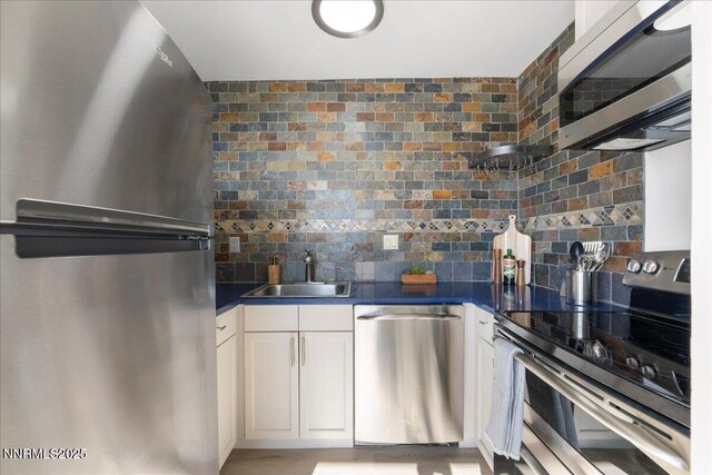 280 Island Ave Apt 906, Reno, NV 89501 - kitchen with stainless steel appliances, dark countertops, white cabinets, and backsplash