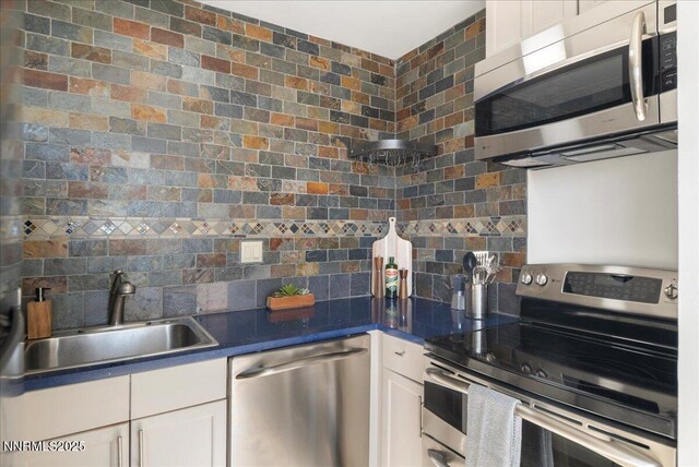 280 Island Ave Apt 906, Reno, NV 89501 - kitchen featuring appliances with stainless steel finishes, decorative backsplash, white cabinets, and dark countertops