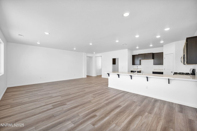 6776 Shell Ct Lot 51, Fernley, NV 89408 - unfurnished living room featuring a sink, light wood-style flooring, recessed lighting, and baseboards