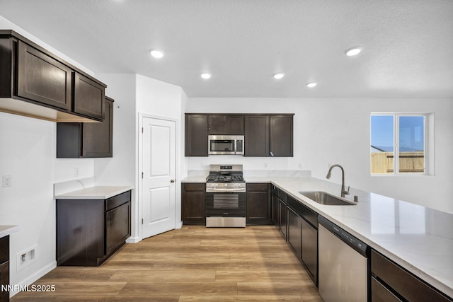 6776 Shell Ct Lot 51, Fernley, NV 89408 - kitchen with appliances with stainless steel finishes, a sink, dark brown cabinets, light wood-type flooring, and recessed lighting