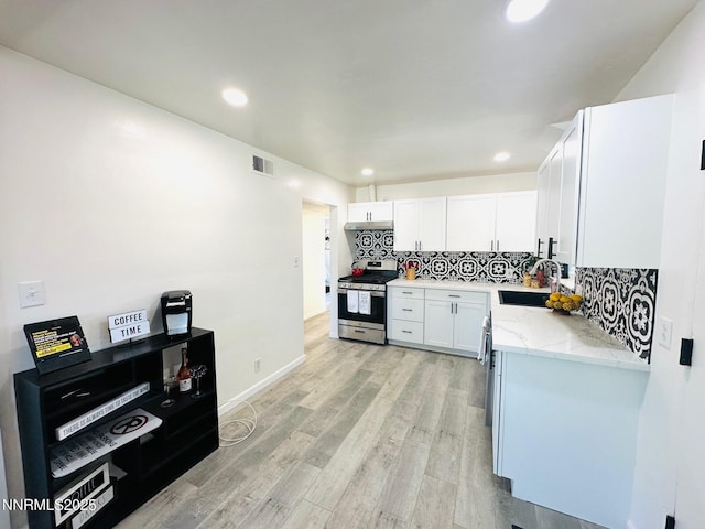 1570 Radclife Dr, Reno, NV 89502 - kitchen featuring gas range, a sink, light stone counters, backsplash, and white cabinets