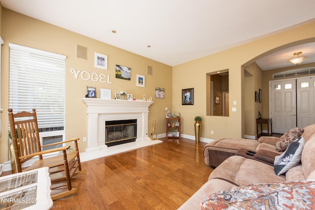 2080 St George Way, Carson City, NV 89703 - living room featuring arched walkways, wood finished floors, baseboards, and a glass covered fireplace