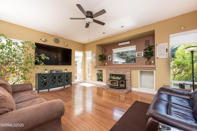 2080 St George Way, Carson City, NV 89703 - living area with ceiling fan, a wood stove, hardwood / wood-style flooring, and plenty of natural light
