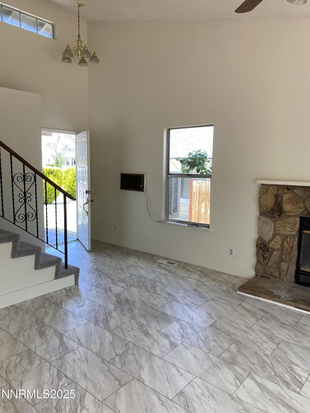 1070 Big Springs Rd, Reno, NV 89523 - unfurnished living room with stairs, marble look tiles, a towering ceiling, a chandelier, and a ceiling fan