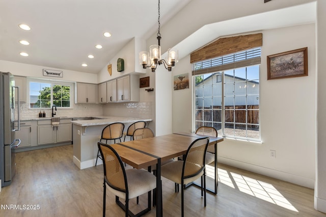 1427 Rosy Finch Dr, Spanish Springs, NV 89441 - dining room with lofted ceiling, light wood-type flooring, a chandelier, and recessed lighting