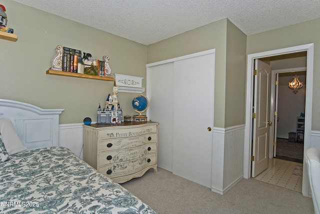 4115 Willowsprings Ct, Reno, NV 89519 - bedroom with light carpet, wainscoting, a closet, and a textured ceiling