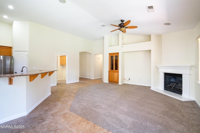 637 Donner Pass Ct, Sparks, NV 89436 - unfurnished living room with ceiling fan, arched walkways, a glass covered fireplace, light tile patterned flooring, and recessed lighting