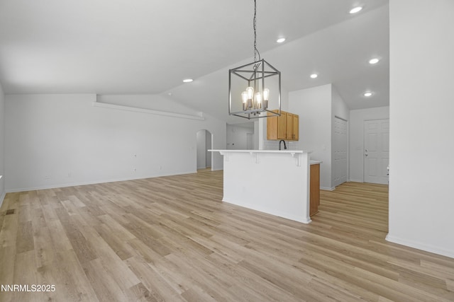 342 Bens Way, Fernley, NV 89408 - kitchen featuring vaulted ceiling, arched walkways, a kitchen breakfast bar, light countertops, and a chandelier